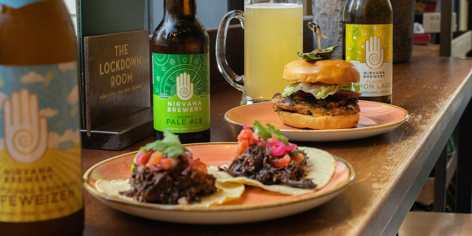 Nirvana Summer BBQ pairings with food on plates in front of nirvana brews