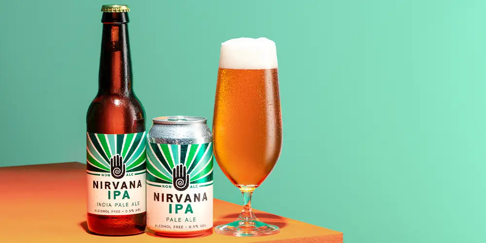 low calorie beer: nirvana IPA image with bottle, can and glass of Nirvana IPA on orange table and green background