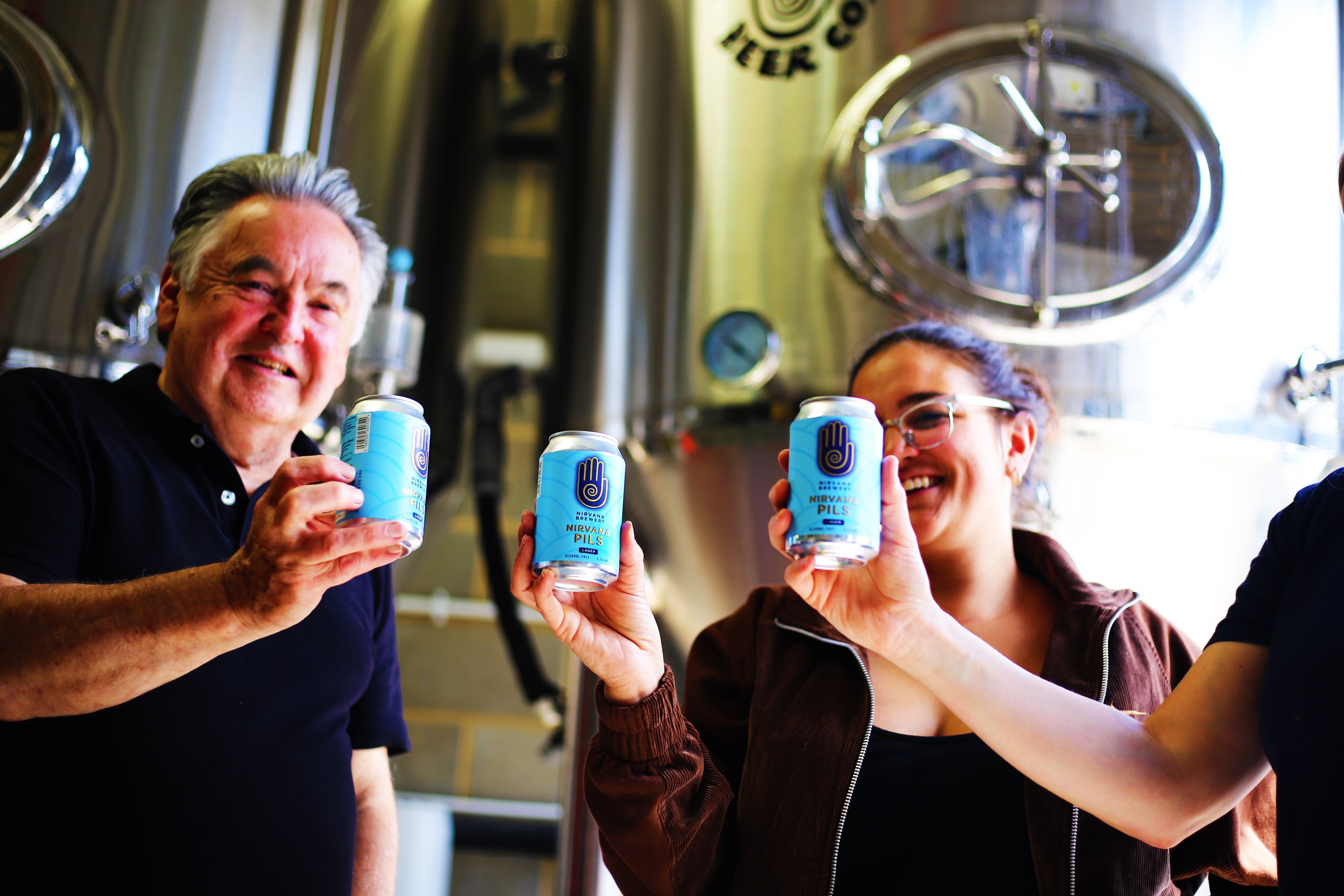 How is Alcoho Free Beer Made? blog image featuring the Nirvana Brewery Team holding up the Nirvana Pilsner at the Brewery