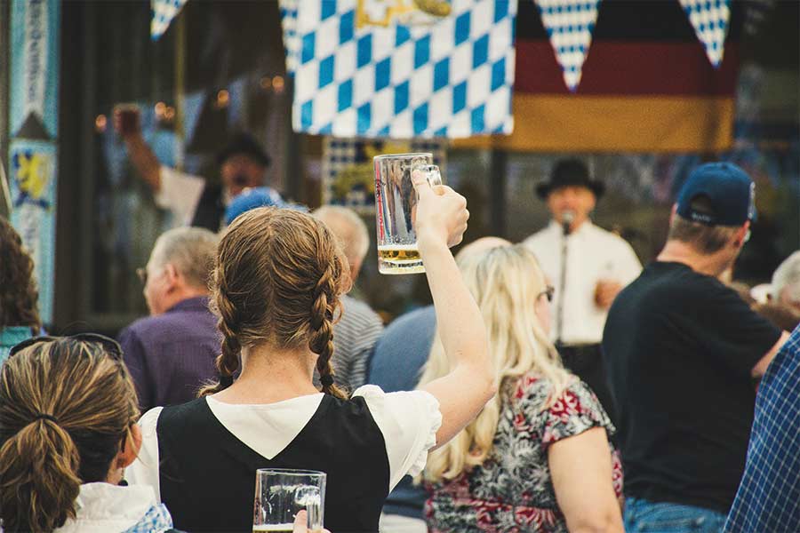 Celebrating Oktoberfest in the UK blog image of a woman at oktoberfest holding up her almost empty beer glass Photo by Brett Sayles: https://www.pexels.com/photo/woman-standing-in-a-crowd-holding-up-beer-glass-1467807/